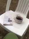 Sur une chaise de jardin, une tasse de café et le livre de Despentes.