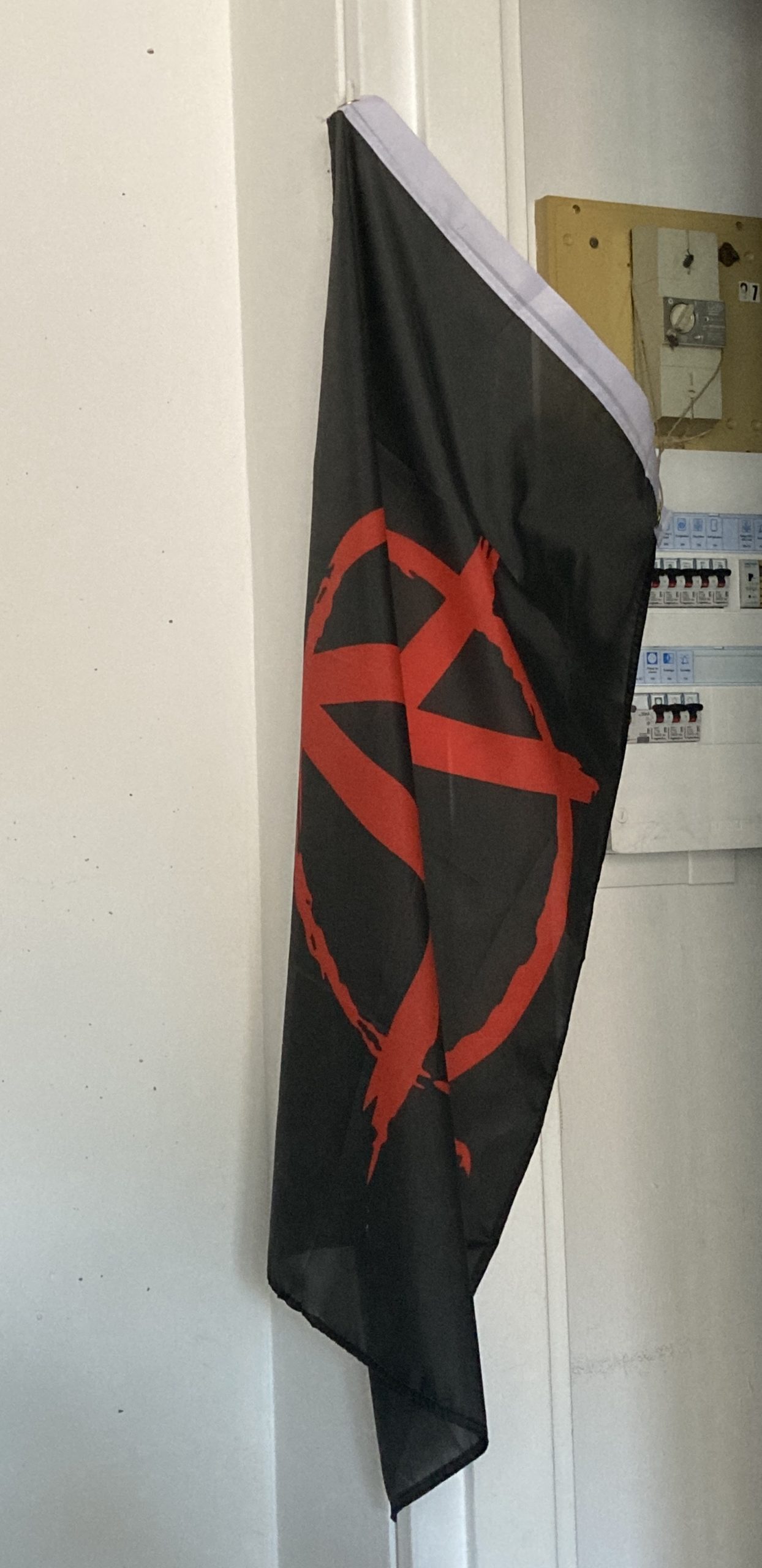 Drapeau anarchiste suspendu a une porte.