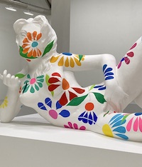 Fragment d'une œuvre de charles Ray, une grande sculputre avec une dame allongée, le corps revouert de dessins de fleurs, sa main à son pubis.